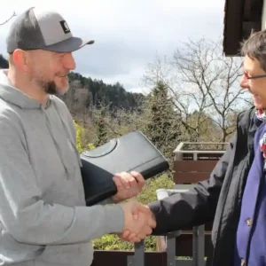 Fertiger SteiStefan Ketterer schüttelt die Hand des Kunden nach Fertigstellung des Projekts für die Balkonsanierung in Freiburg.ung