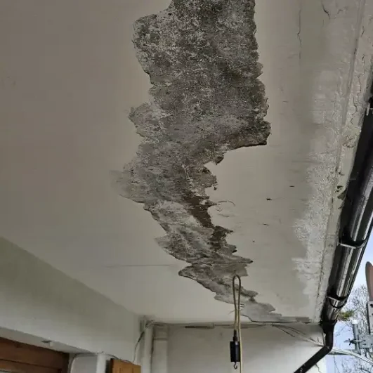 Abgeblätterter Putz und Feuchtigkeitsschäden an einer Balkonunterseite vor dem Balkon renovieren nahe Offenburg.